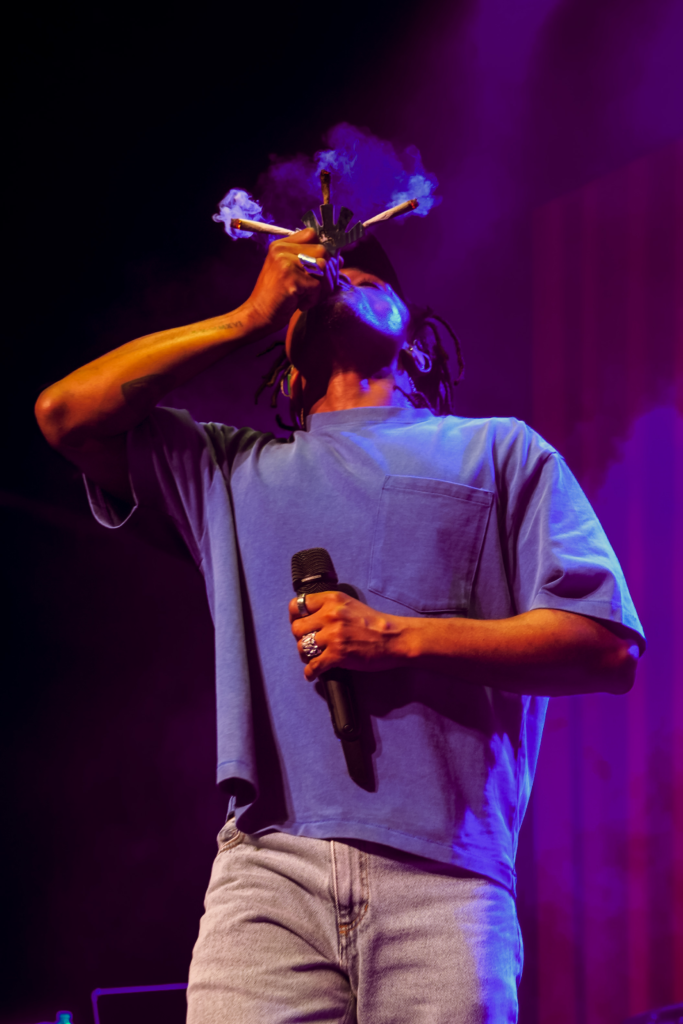 Candid of Jordan Ward smoking three joints at once with a microphone in his hand.